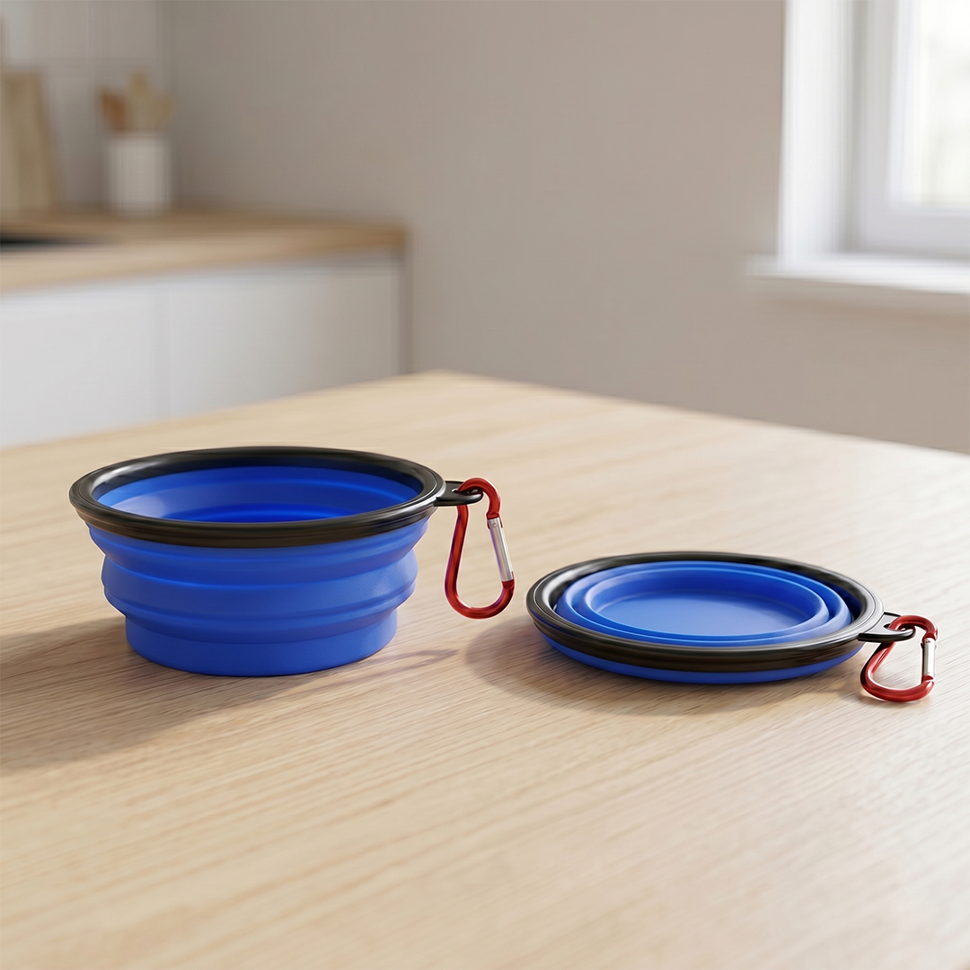 Collapsible blue pet bowls with black rims and red carabiners on a wooden surface.